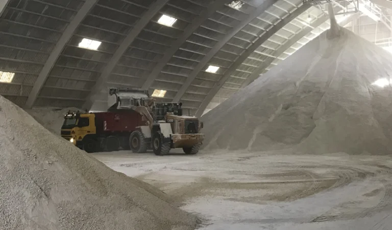 Traktor skyfflar kalk på lastbil.