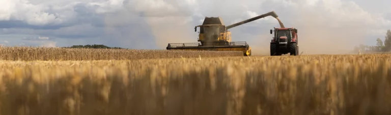 Tröska-och-traktor-vid-spannmålsskörd-i-Västergötland